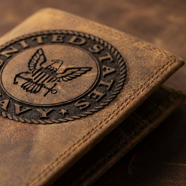 Close-up of a distressed brown leather wallet embossed with the United States Navy eagle and anchor logo.
