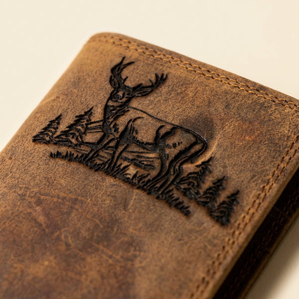 Brown distressed leather rodeo wallet with an embossed deer and forest scene.